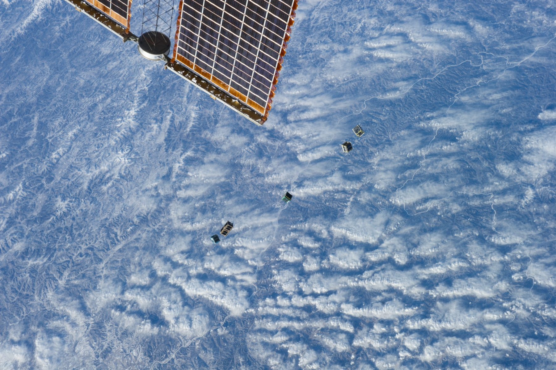Small satellites deploying above Earth